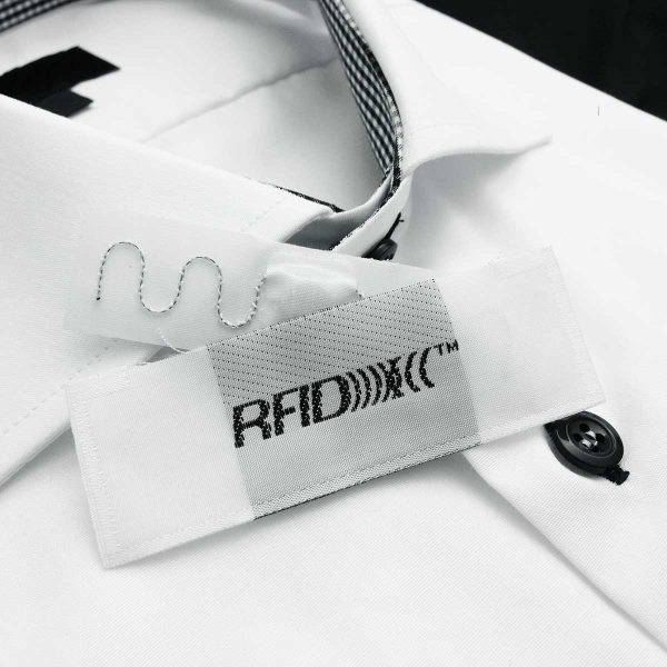 vit skjorta med svarta knappar och RFID transpondrar för enkel snabb och säker spårbarhet symboliserar smart plagghentering artikelhantering klädhantering med högkvalitativa digitaliserade logistiksystem från ACG Pulse.