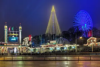 Julmarknadskväll på Liseberg härlig julstämning. Entre till nöjesparken, Ett pariserhjul högt placerat med blått ljus.