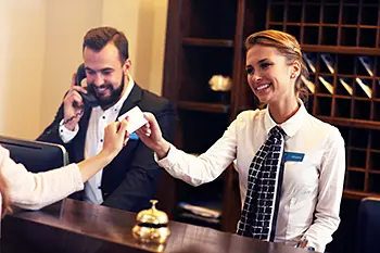 Smiling hotel receptionist, high-quality digitalized logistics systems for hotell and restaurants.