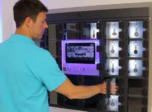 Smart varuautomat med lånefunktion. Man i blå piké t-shirt lånar bilnycklar ur en Smart varuautomat med lånefunktion Q-Lock från ACG Pulse AB in Sweden.